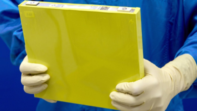 An employee holds a full-size prototype LMR battery cell at the General Motors Wallace Battery Cell Innovation Center in Warren, Michigan. Photo by Steve Fecht for General Motors. Image source: GM